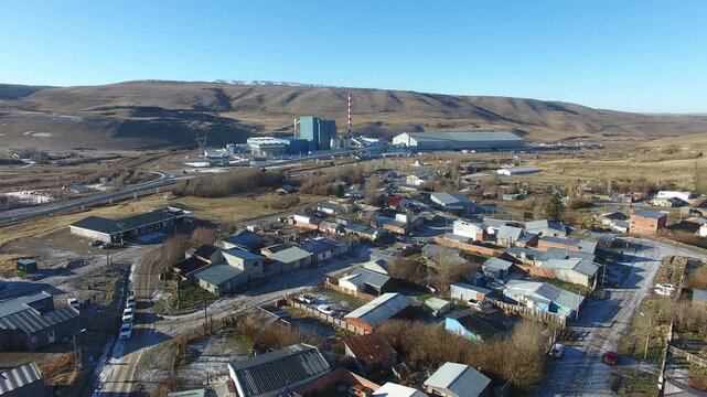 4K aerial drone footage flying over Julia Dufour, a Patagonian megausina in Santa Cruz, Argentina. Scenic urban landscape surrounded by rugged mountains, showcasing the beauty of southern Patagonia.