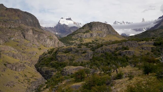 Andean Mountain Landscape in Los Glaciares National Park. A sweeping landscape view of the rugged Andes in Patagonia, featuring a deep valley, ancient Nothofagus forests, and distant snow-capped peaks