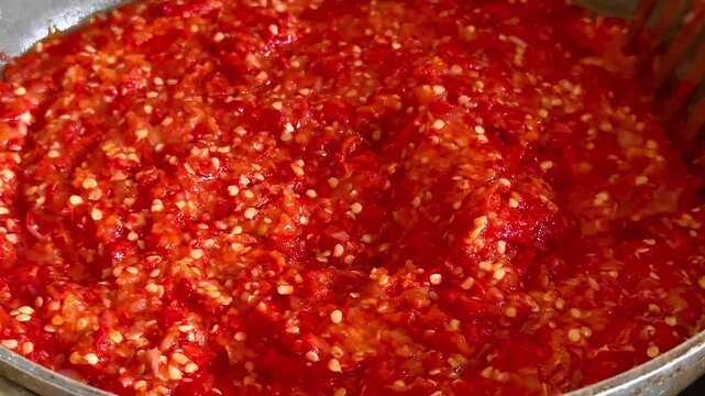 Close up of stirring traditional fried red sambal chili paste