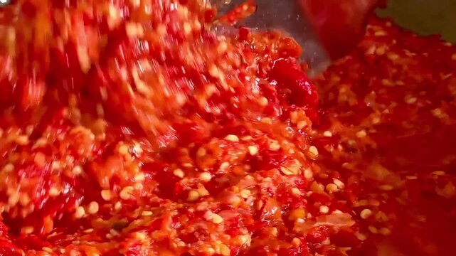 Close up of stirring traditional fried red sambal chili paste