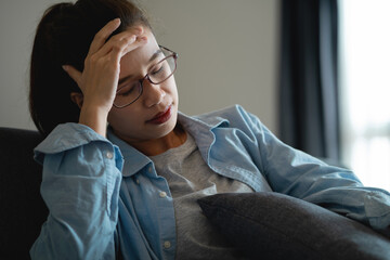 Fototapeta premium Young Asian Woman Suffering from Headache and Mental Stress After Excessive Smartphone Use at Home, Digital Burnout, Screen Fatigue, Work From Home Lifestyle and Health Awareness