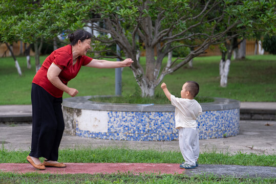 Asian grandmother playing with toddler grandson in park