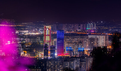 Fototapeta premium Urban skyline illuminated with colorful lights at night Sanya, Hainan Island, China
