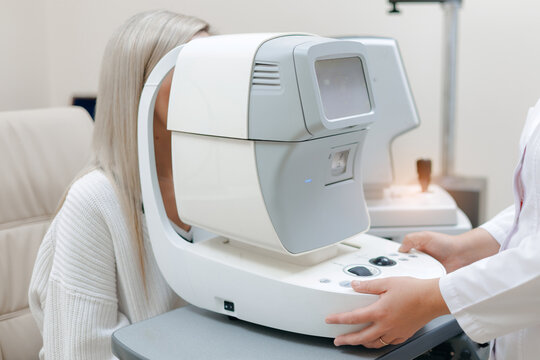 Woman undergoing eye examination with autorefractor in clinic, workplace of Ophthalmologist doctor