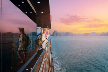 Scenic sunset at Halong bay with woman on cruise ship deck in Vietnam