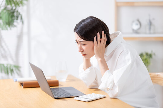 ノートパソコン　悩む女性