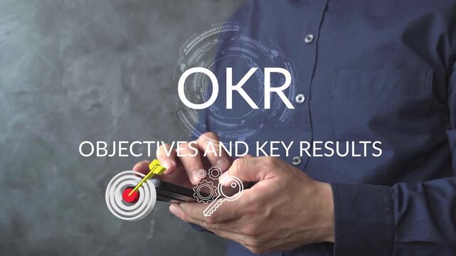 Business professional using a smartphone with an OKR interface, target, strategy, and performance icons representing measurable objectives, planning, achievement, and organizational growth.