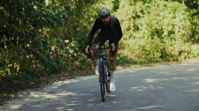 Cyclist Riding Bicycle On Asphalt Road In Forest. Cycling Athlete Training. Healthy Lifestyle