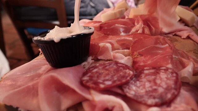 Italian charcuterie board with prosciutto and Squacquerone cheese celebrating traditional Italian cuisine. Tagliere di salumi.