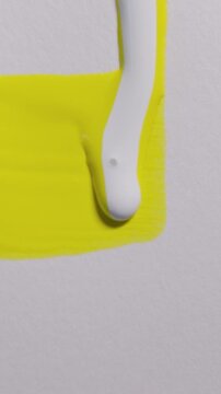 Vertical white yellow paint dripping down white textured paper background