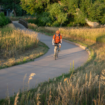 Senior male cyclist is commuting on a bike trail in Fort Collins in northern Colorado, late summer scenery