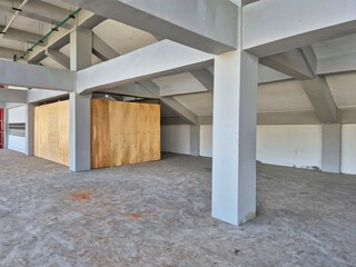 Obraz premium Interior concrete ceiling with exposed utility pipes and structural beams in an unfinished industrial building