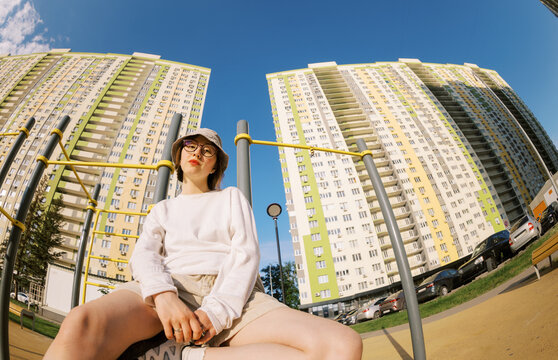 Young Person Sitting on Playground Equipment in Urban Setting