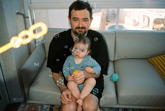 Portrait of a father with baby and soap bubbles