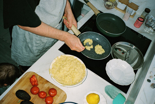 Anonymous man cooking potato pancakes