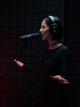 Woman Sings in a Recording Studio With a Microphone