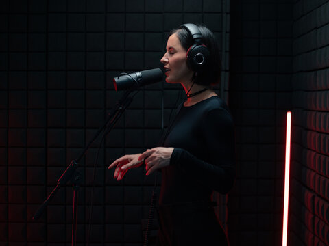 Woman singing in studio using microphone 