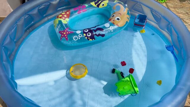 Inflatable swimming pool with toys floating on the water