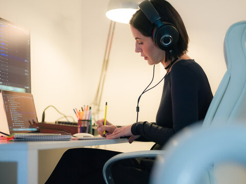 Woman writing notes in notebook at office 