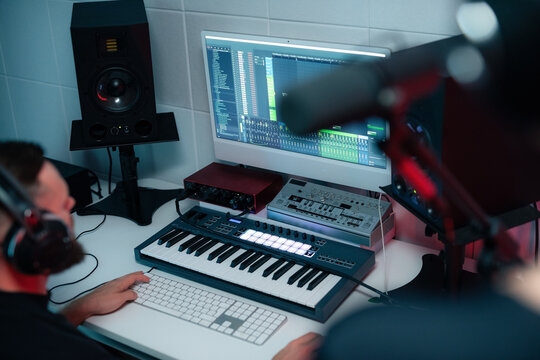 Music Producer Working in a Studio With Equipment and Monitors