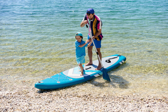 Father Teaching Son Stand Up Paddleboarding