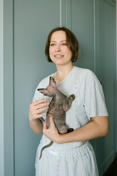 Woman Holding Devon Rex Cat at Home