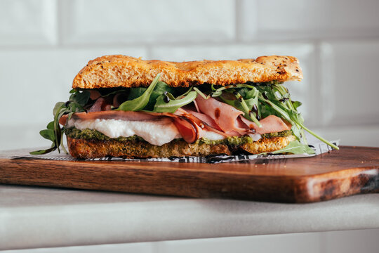 Gourmet Italian focaccia sandwich with prosciutto and arugula