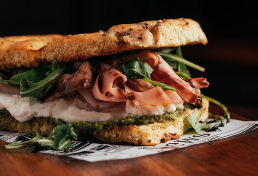 Gourmet ham and pesto focaccia on rustic bread close-up