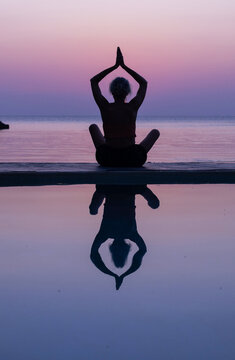 silhouette of woman practicing yoga and meditation at sunset
