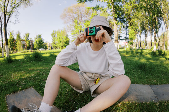 Young Person Taking Pictures Outdoors in the Park on a Sunny Day
