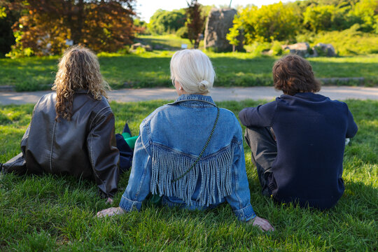 family sitting on the grass in the park
