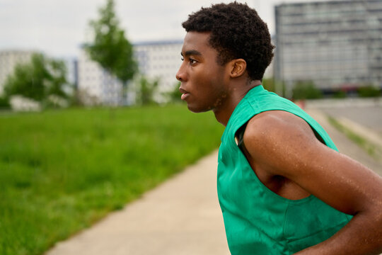 Runner Trains on City Path During Cloudy Afternoon