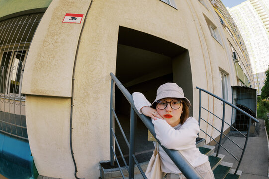 Model Leans on Railing Outside Building During Daytime