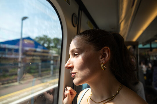 Woman looking out train window during journey in London