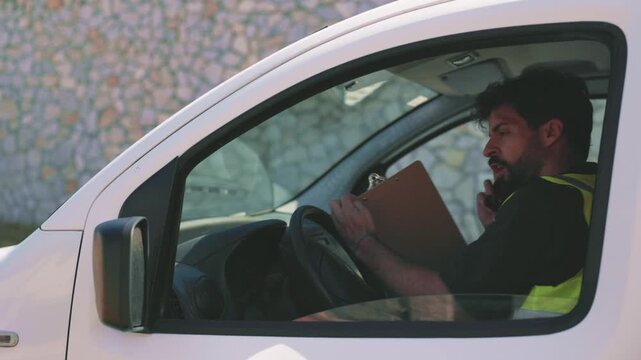Angry delivery driver yelling on the phone inside his transport van