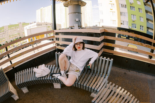 Woman Sitting on Bench in Urban Setting During Daytime