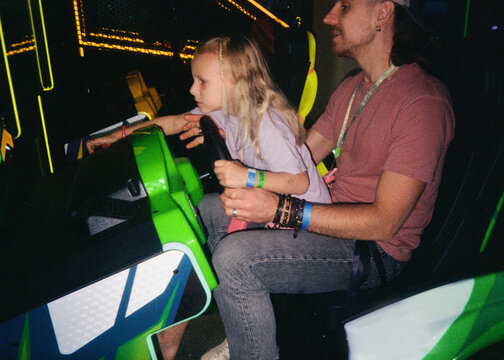 Father and Daughter Playing Arcade Racing Game Together