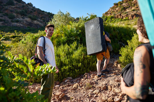 Friends go bouldering together on a sunny day in the mountains