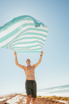Man Shaking Out Beach Towel