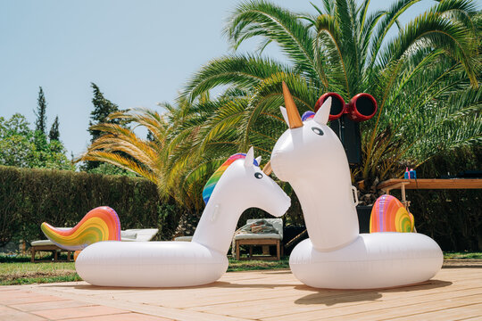 Unicorn inflatable pool floats in tropical resort garden