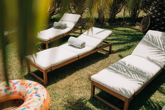 Luxury sun loungers with towels in tropical garden