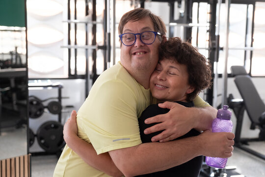 Person and trainer sharing a supportive moment in gym