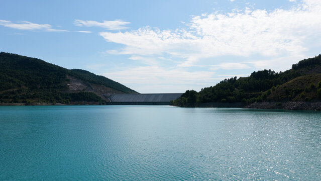 Yesa reservoir, a large dam and turquoise water creating an impressive landscape in the Pyrenees mountains on a sunny day