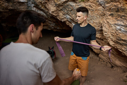 Climbers training with resistance bands in a cave setting