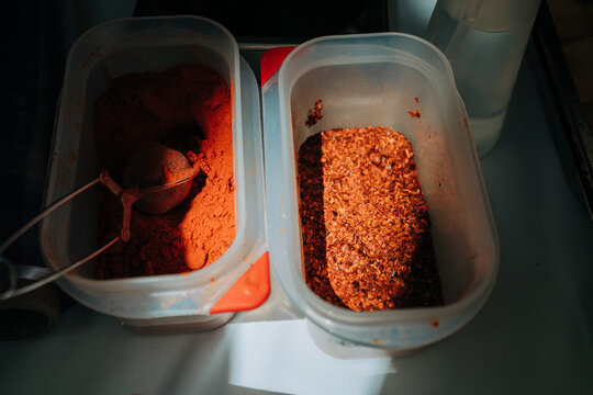 Ground spices and seasoning flakes in kitchen containers
