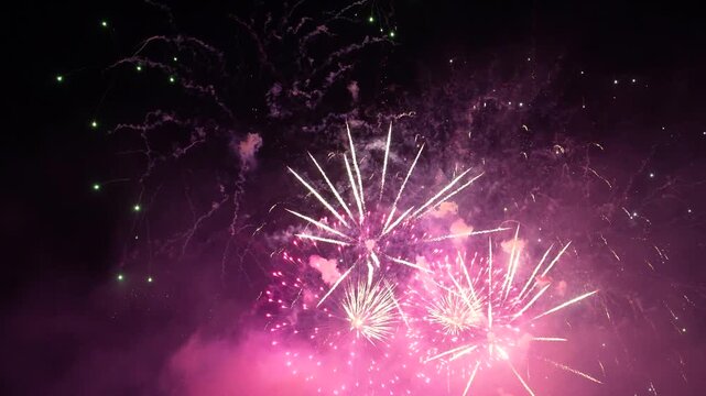 Multiple fireworks burst in the dark night sky over China. Brilliant sparks, bright flashes, and colorful explosions create a fun holiday celebration