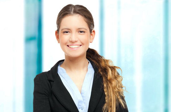 Portrait of a cheerful young businesswoman in office attire with