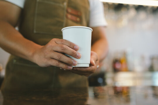 Barista serving a freshly crafted latte with elegant latte art, offering a warm specialty coffee experience in a cozy caf&eacute;.