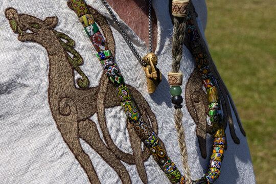 Shieldmaiden silver pendant necklace and colorful beads and tunic with dragon motif.