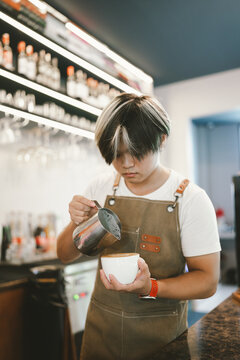 Professional barista preparing espresso with a commercial coffee machine in a modern specialty caf&eacute;.